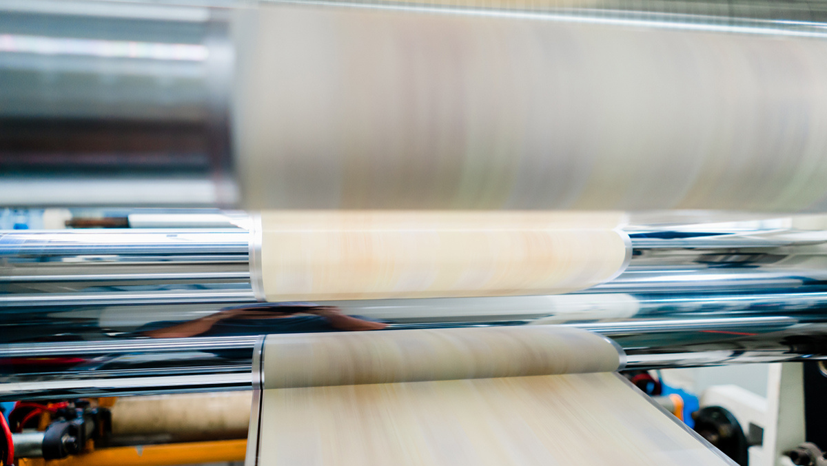 Industrial rollers processing flexible film in a high-speed packaging and recycling line.